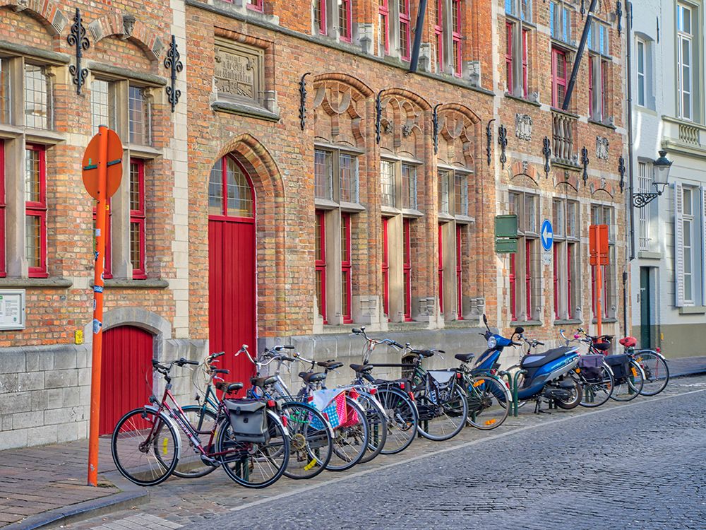 Belgium-Brugge. Bicycles parked along the street.
